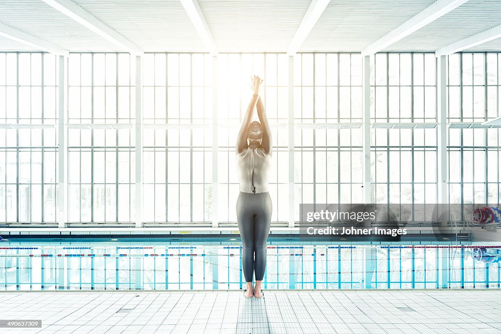 Mid adult woman in wetsuit at swimming pool