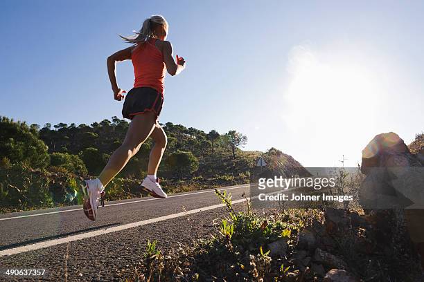 runner running on road, low angle view - uphill stockfoto's en -beelden