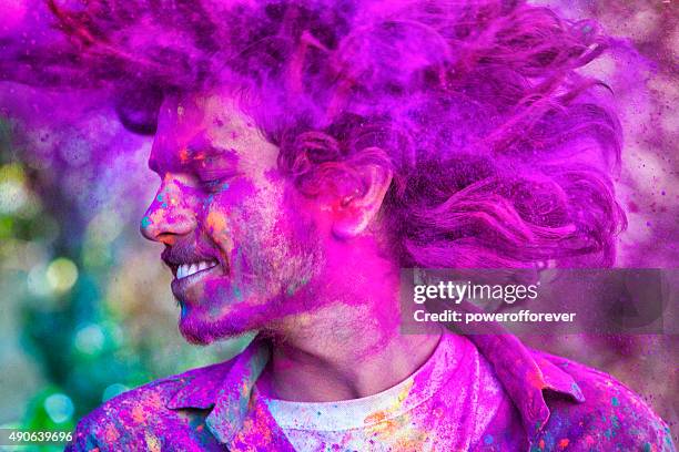 giovane uomo che celebra holi festival in india - holi foto e immagini stock