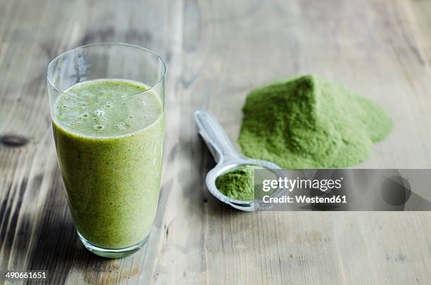 moringa powder on spoon and wooden table and glass of moringa smoothie - moringa oleifera 個照片及圖片檔