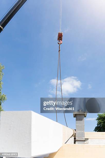 construction of a residential house, assembling of the roof - crane hook stock-fotos und bilder