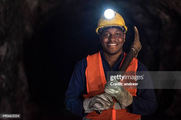 happy miner working at a mine underground - mijnwerker stockfoto's en -beelden
