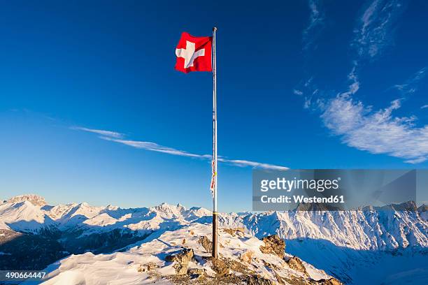 switzerland, graubuenden, savognin, mountaintop piz martegnas, swiss flag - swiss flag stock pictures, royalty-free photos & images