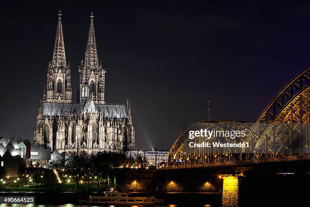 germany, north rhine-westphalia, cologne, cologne cathedral and hohenhollern bridge over the rhine river by night - keulen stockfoto's en -beelden