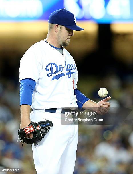 Starting pitcher Paul Maholm of the Los Angeles Dodgers flips the ball as he waits to be relieved in the fourth inning in the game with the Miami...