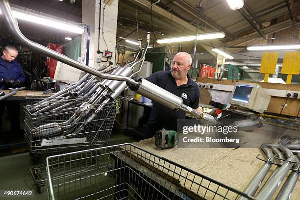 An employee moves a completed automobile catalytic converter emission control device at BM Catalysts in Mansfield, U.K., on Wednesday, Sept. 30,...