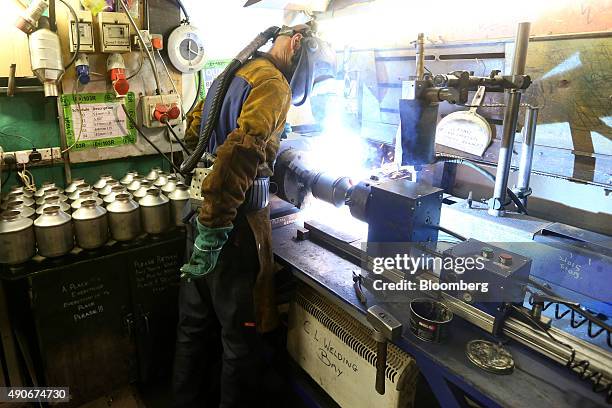 An employee welds parts on to a automobile catalytic converter emission control device at BM Catalysts in Mansfield, U.K., on Wednesday, Sept. 30,...