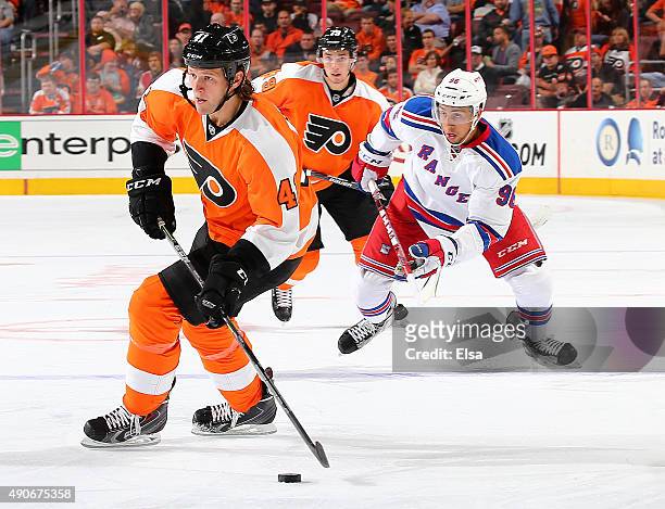 Jay Rosehill of the Philadelphia Flyers takes the puck as Emerson Etem of the New York Rangers defends on April 7, 2015 at the Wells Fargo Center in...