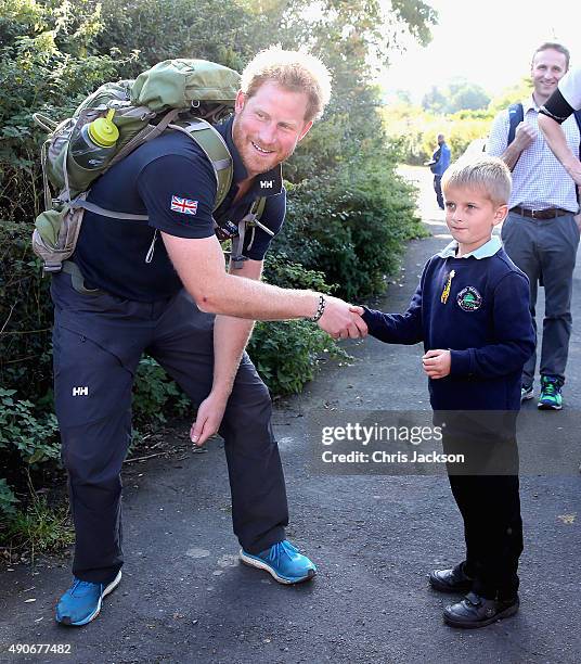 Prince Harry meets a young school boy on the route to Ludlow with Walking with the Wounded's Walk of Britain team on September 30, 2015 in Ludlow,...