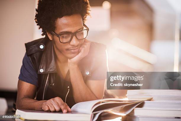 smiling african american young man studying. - reading glasses 個照片及圖片檔