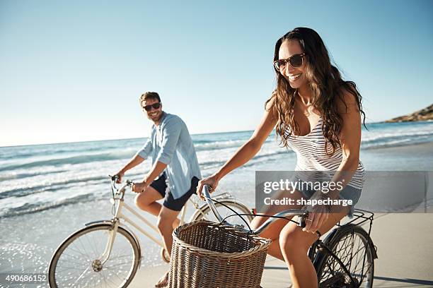 die besten dinge im leben sind kostenfrei. - fun couple on bike stock-fotos und bilder