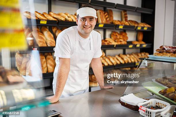 smiling baker looking at camera in bakery. - baker man stock pictures, royalty-free photos & images
