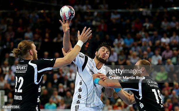 Domagoj Duvnjak of Kiel challenges for the ball with Fabian Gutbrod and Max Weiss of Bergischer HC during the DKB HBL Bundesliga match between THW...