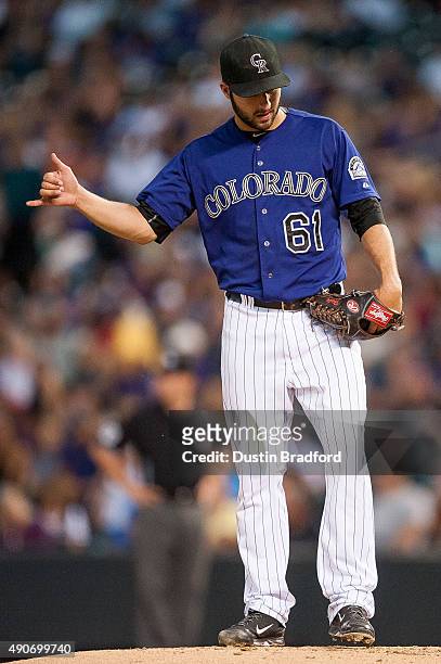David Hale of the Colorado Rockies signals to the infield as he pitches in the third inning of a game against the Los Angeles Dodgers at Coors Field...