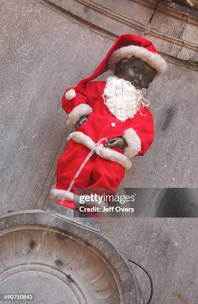 Mannekin Pis - dressed as Santa for Christmas. Mannekin Pis is a fountain made of a statue of a small boy urinating, Brussels, Belgium.