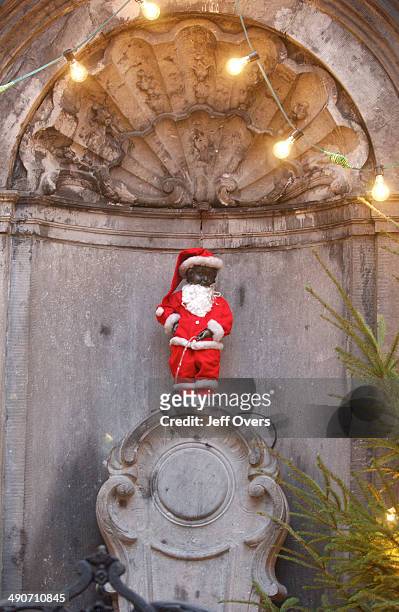 Mannekin Pis - dressed as Santa for Christmas. Mannekin Pis is a fountain made of a statue of a small boy urinating, Brussels, Belgium.