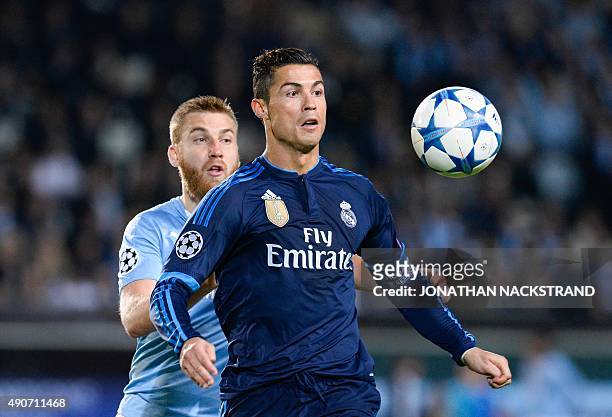 Real Madrid's Portuguese forward Cristiano Ronaldo and Malmo's Norwegian midfielder Jo Inge Berget vie for the ball during the UEFA Champions League...