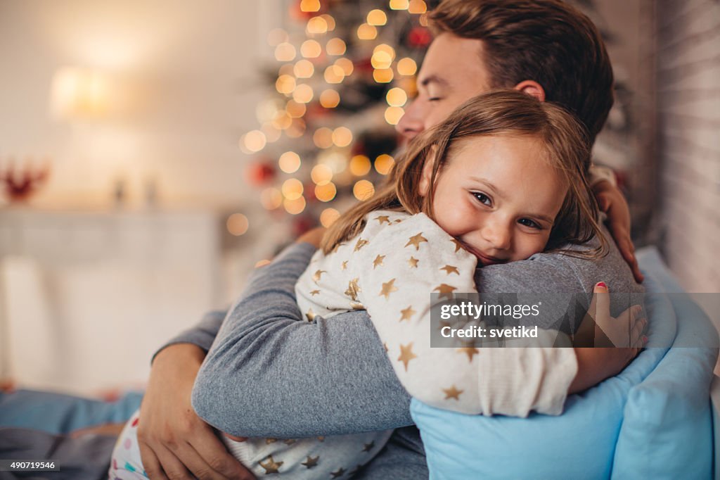 Father and his cute daughter in front of christmas three.