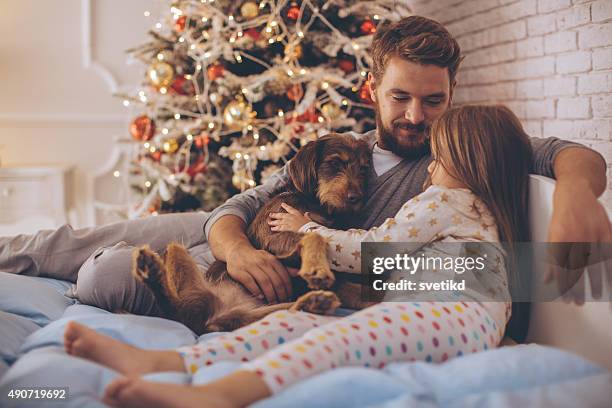 father and his cute daughter in front of christmas three. - christmas dog 個照片及圖片檔