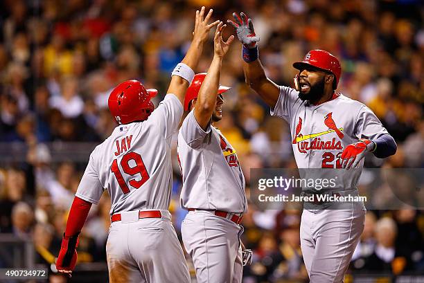 Jason Heyward of the St Louis Cardinals is congratulated at home plate by teammate Jon Jay after hitting a grand slam home run in the third inning...