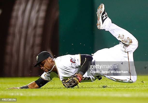 Starling Marte of the Pittsburgh Pirates slides but fails to come up with a catch in left field in the 8th inning against the St Louis Cardinals...