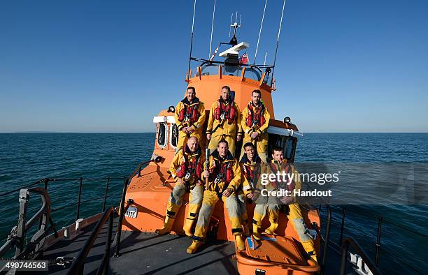 In this handout image provided by Glasgow 2014 Ltd, Jason Norman, Skipper of the St Peter Port Lifeboat 'Spirit of Guernsey', holds the Queen's Baton...