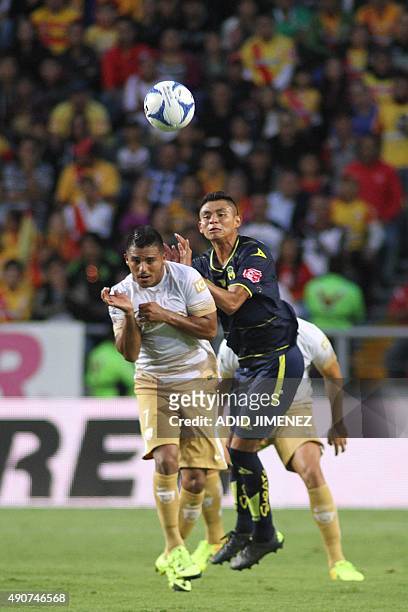 Miguel Sansores of Morelia vies for the ball with Javier Cortes of Pumas, during their Mexican Apertura 2015 tournament football match at the Morelos...