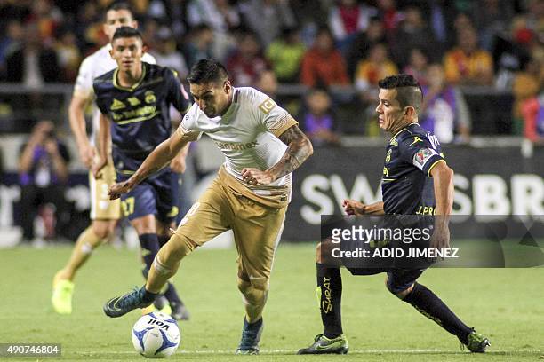 Juan Pablo Rodriguez of Morelia vies for the ball with Ismael Sosa of Pumas during their Mexican Apertura 2015 tournament football match at the...