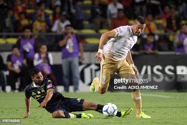 Jose Olvera of Morelia vies for the ball with Dante Lopez of Pumas during their Mexican Apertura 2015 tournament football match at the Morelos...