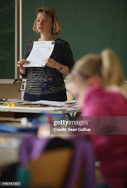 Volunteer teacher Andrea Urban, who is also the mother of two of her pupils, teaches a technology class at the Middle School on May 14, 2014 in...