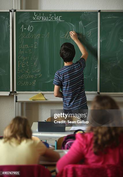 Sixth grader Dominic Bergel writes out the words for numbers during Czech language class at the Middle School on May 14, 2014 in Seifhennersdorf,...