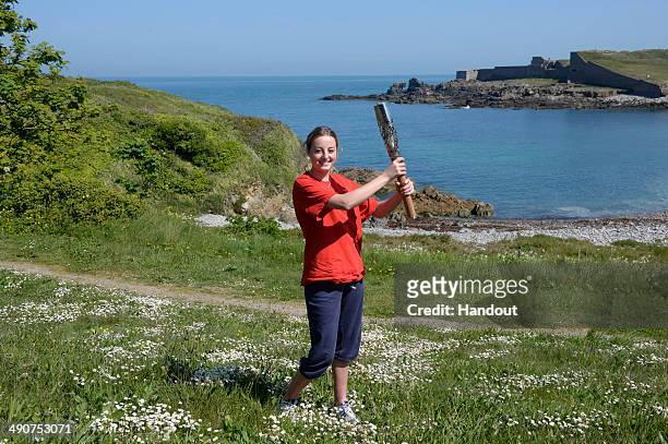 In this handout image provided by Glasgow 2014 Ltd, Emma Etheredge, aged 15, carries the Commonwealth Games Baton as it makes it's way around the...