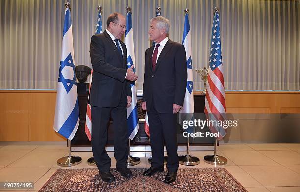 Israeli Defense Minister Moshe Ya'alon poses with US Defense Secretary Chuck Hagel before a bilateral meeting at The Kirya, the Israeli Defense Force...