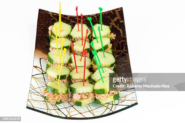 Healthy snack for diabetics: tuna and cucumber sandwiches or finger foods made of tuna sandwiched in cucumber slices, arranged in a decorative curved...