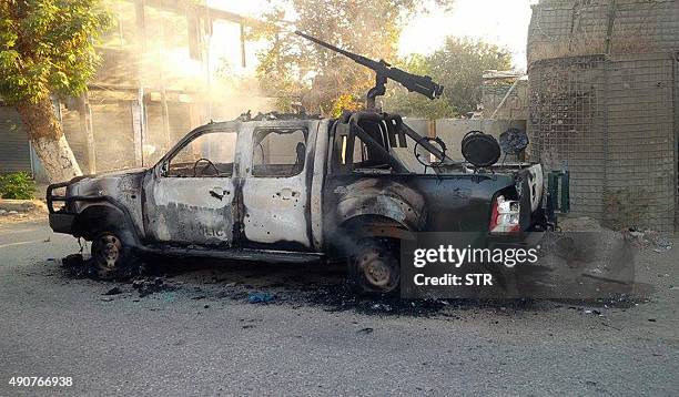 Burnt-out police pick-up truck stands in the street after Afghan security forces retook control of Kunduz city from the Taliban militants in...