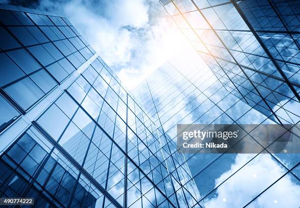 view of a contemporary glass skyscraper reflecting the blue sky - abstract clouds bildbanksfoton och bilder