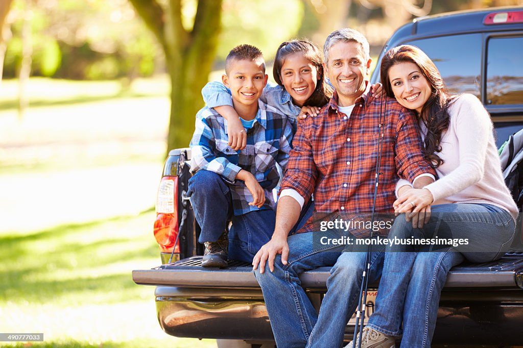 Family Sitting In Pick Up Truck On Camping Holiday