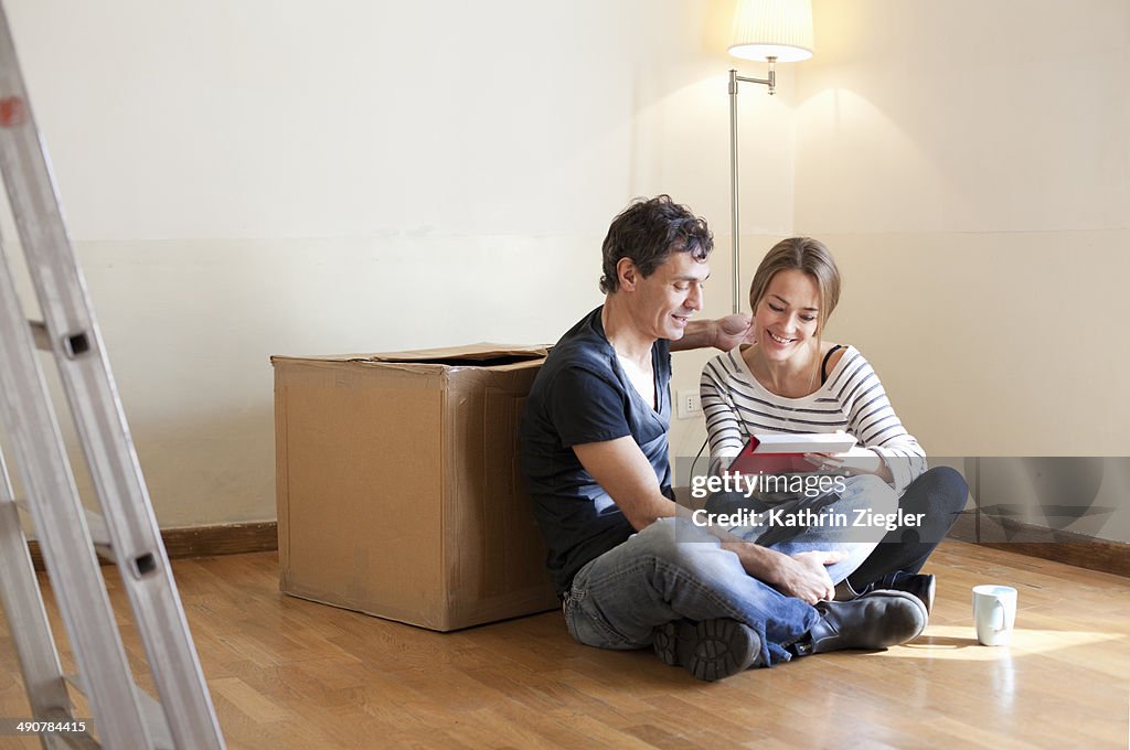 Couple sitting on floor in their new, empty house