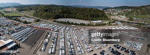 An aerial view and composite photograph of automobiles stockpiled at the Swiss auto distributor AMAG, a unit of Careal Holding AG, with brands...