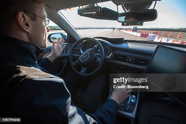 An employee drives an Audi A6 diesel automobile, produced by Volkswagen AG , handsfree during an automated driving exercise on a test track at the...