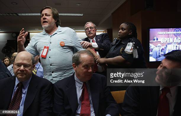 Activist Kevin Zeese is pulled away as he protests during an open meeting to receive public comment on proposed open Internet notice of proposed...