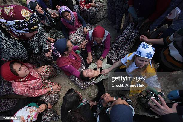 Turkish woman faints during the funeral of the the miners after a mining disaster on May 15, 2014 in Soma, a district in Turkey's western province of...