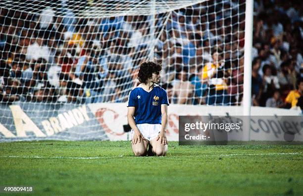 French forward Didier Six knees on the pitch during the 1982 World Cup semifinal football match between West Germany and France on July 8, 1982 in...