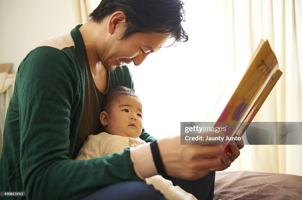 Father reading a picture book for his baby