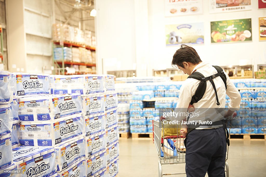 Father shopping in the super market with his baby