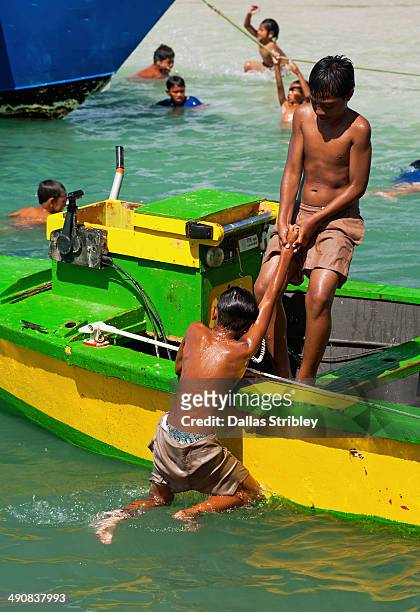 boys playing on boat moored in avarua harbour - rarotonga fotografías e imágenes de stock