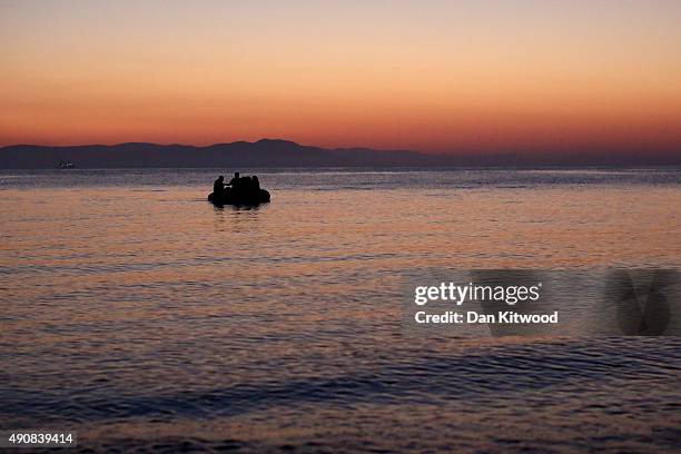 Migrant families from Syria arrive in an inflatable dinghy on the beach at sunrise on the island of Kos after crossing a three mile stretch of the...