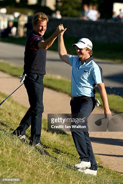 Eddie Pepperell of England is congratulated by Mark Nicholas after chipping in on the 17th green during the first round of the 2015 Alfred Dunhill...