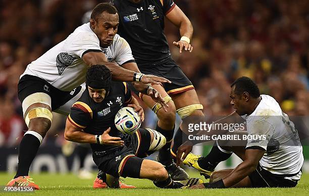 Wales' full-back Matthew Morgan falls next to Fiji's lock Leone Nakarawa and Fiji's centre Vereniki Goneva during a Pool A match of the 2015 Rugby...