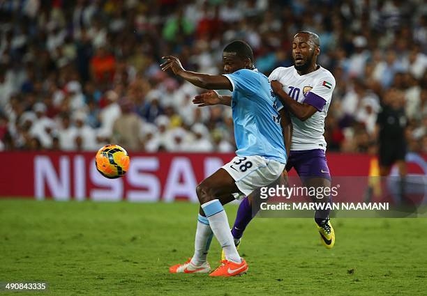 Dedryck Boyata of newly-crowned English Premier League champions Manchester City football team is challenged by UAE's Al-Ain player Ismail Matar...